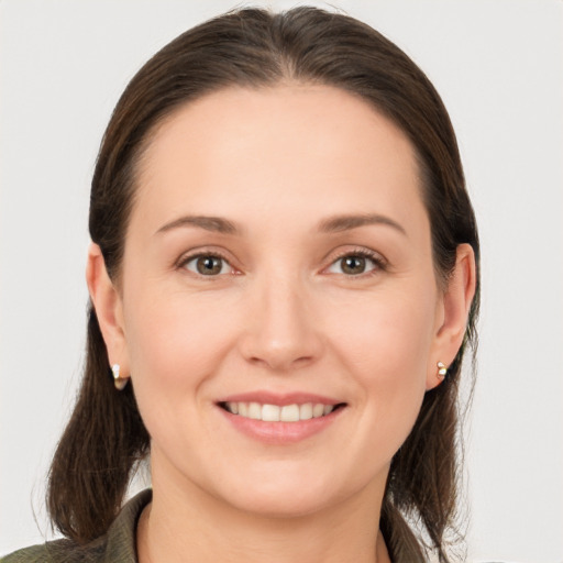 Joyful white young-adult female with long  brown hair and brown eyes