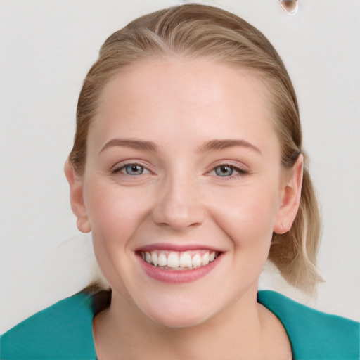 Joyful white young-adult female with medium  brown hair and blue eyes