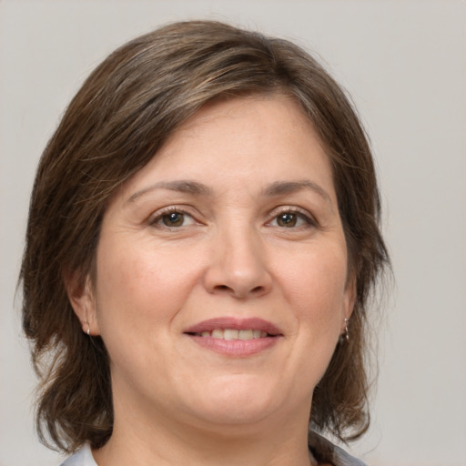 Joyful white adult female with medium  brown hair and grey eyes