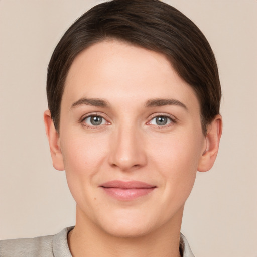 Joyful white young-adult female with short  brown hair and grey eyes