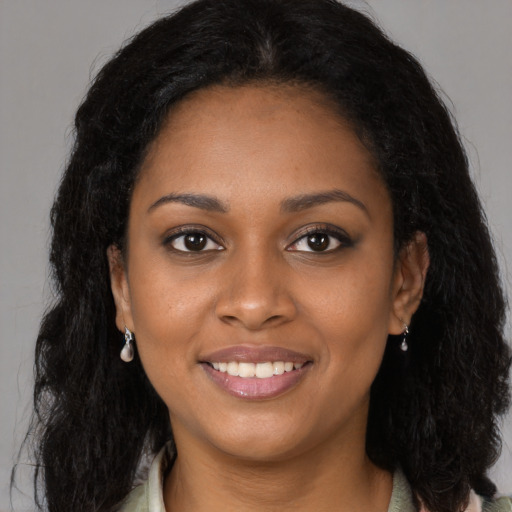 Joyful black young-adult female with long  brown hair and brown eyes