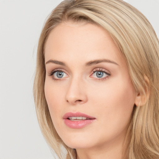 Joyful white young-adult female with long  brown hair and blue eyes