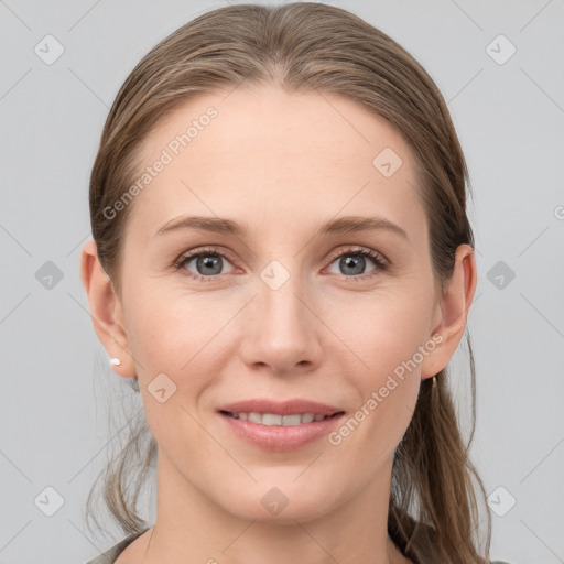 Joyful white young-adult female with medium  brown hair and grey eyes