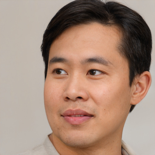 Joyful asian young-adult male with short  brown hair and brown eyes