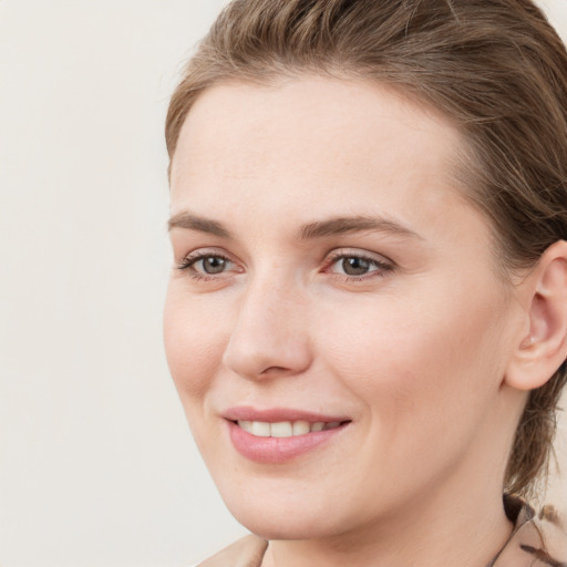 Joyful white young-adult female with medium  brown hair and grey eyes