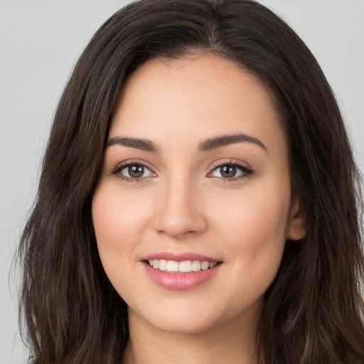 Joyful white young-adult female with long  brown hair and brown eyes