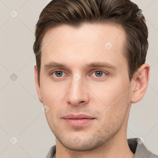 Joyful white young-adult male with short  brown hair and grey eyes