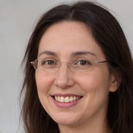 Joyful white adult female with long  brown hair and grey eyes