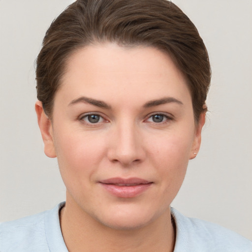 Joyful white young-adult female with short  brown hair and grey eyes