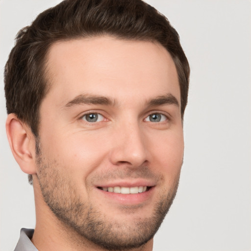 Joyful white young-adult male with short  brown hair and grey eyes