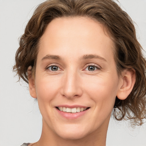 Joyful white young-adult female with medium  brown hair and green eyes