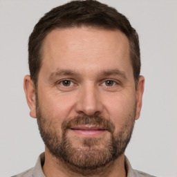 Joyful white adult male with short  brown hair and brown eyes