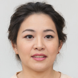 Joyful asian young-adult female with medium  brown hair and brown eyes