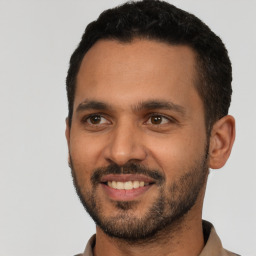 Joyful latino young-adult male with short  black hair and brown eyes