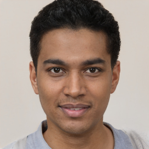 Joyful black young-adult male with short  black hair and brown eyes