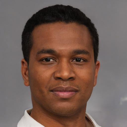 Joyful black young-adult male with short  black hair and brown eyes