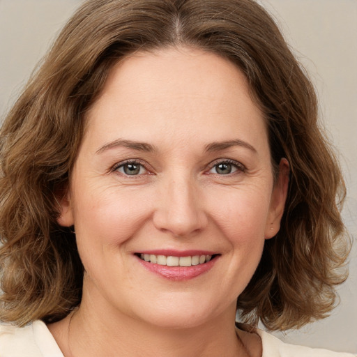 Joyful white adult female with medium  brown hair and brown eyes