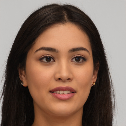 Joyful latino young-adult female with long  brown hair and brown eyes
