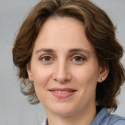 Joyful white young-adult female with medium  brown hair and green eyes