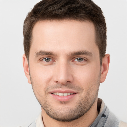 Joyful white young-adult male with short  brown hair and grey eyes