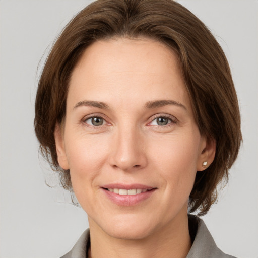 Joyful white adult female with medium  brown hair and grey eyes