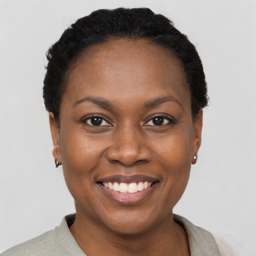 Joyful black young-adult female with short  black hair and brown eyes