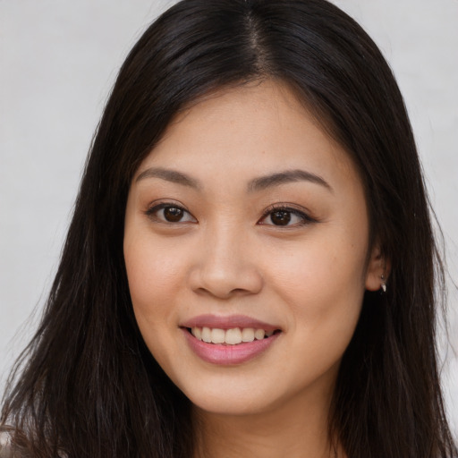 Joyful asian young-adult female with long  brown hair and brown eyes