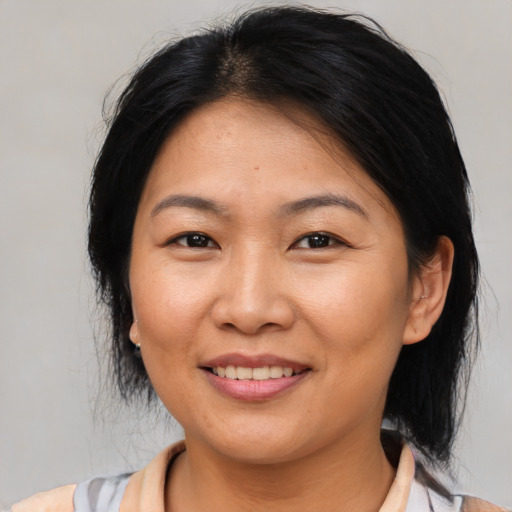 Joyful asian adult female with medium  brown hair and brown eyes