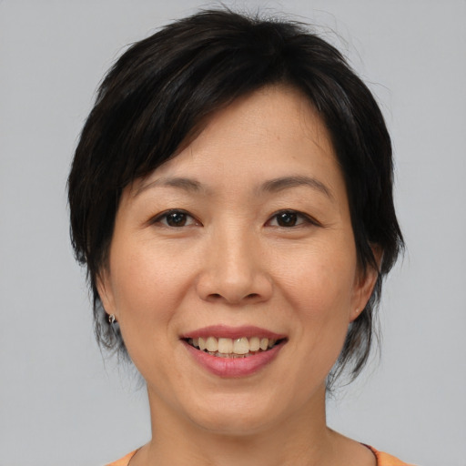 Joyful asian adult female with medium  brown hair and brown eyes