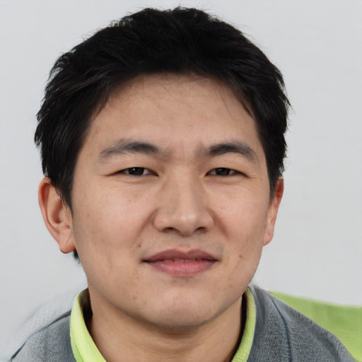 Joyful asian adult male with short  brown hair and brown eyes