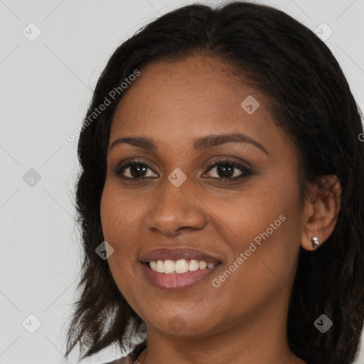 Joyful black young-adult female with long  brown hair and brown eyes