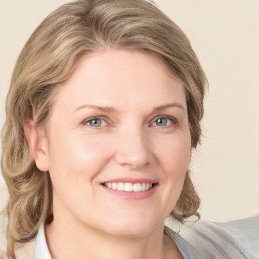 Joyful white young-adult female with medium  brown hair and blue eyes