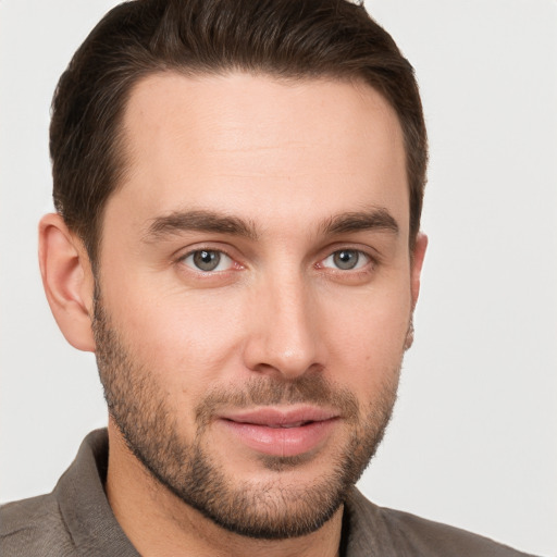 Joyful white young-adult male with short  brown hair and grey eyes