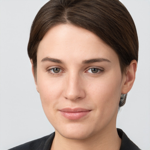 Joyful white young-adult female with short  brown hair and grey eyes