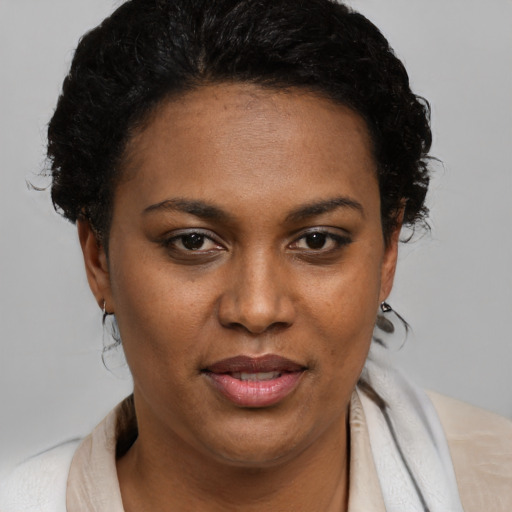 Joyful black young-adult female with short  brown hair and brown eyes