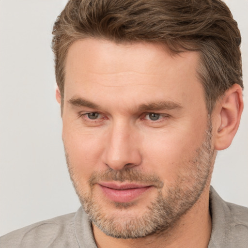 Joyful white adult male with short  brown hair and brown eyes