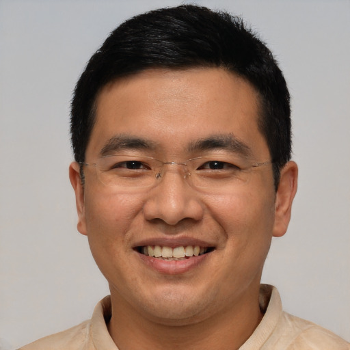 Joyful asian adult male with short  brown hair and brown eyes