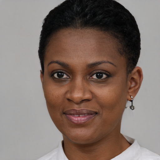 Joyful black young-adult female with short  black hair and brown eyes