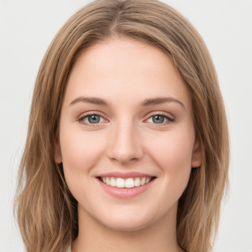 Joyful white young-adult female with long  brown hair and green eyes