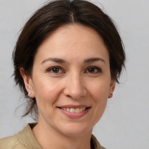 Joyful white adult female with medium  brown hair and brown eyes