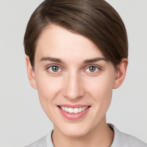 Joyful white young-adult female with short  brown hair and grey eyes