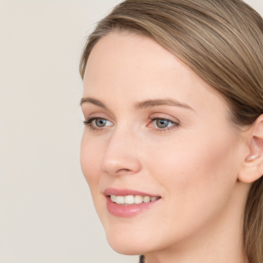 Joyful white young-adult female with long  brown hair and blue eyes