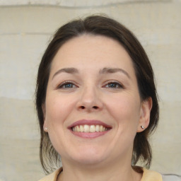 Joyful white adult female with medium  brown hair and brown eyes