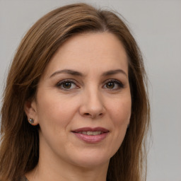 Joyful white adult female with long  brown hair and brown eyes