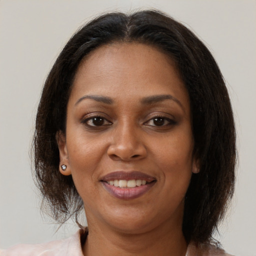 Joyful black adult female with medium  brown hair and brown eyes