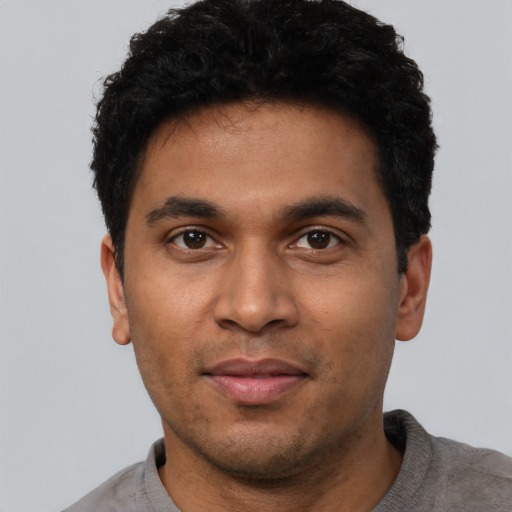 Joyful latino young-adult male with short  black hair and brown eyes