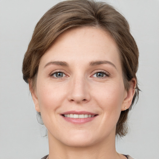 Joyful white young-adult female with medium  brown hair and grey eyes