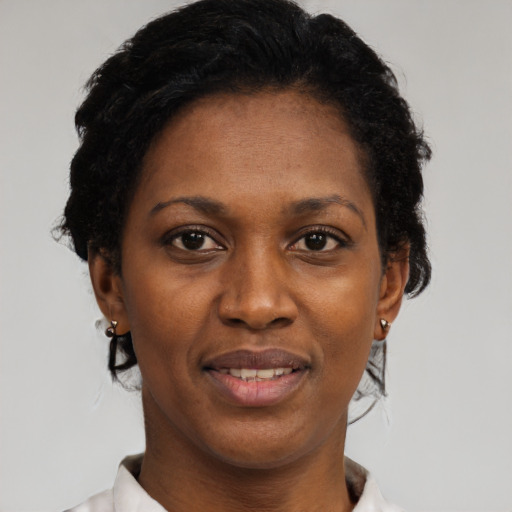 Joyful black adult female with short  black hair and brown eyes