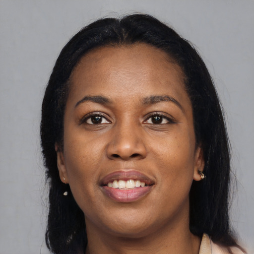 Joyful black young-adult female with long  black hair and brown eyes