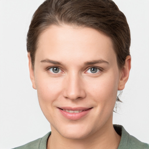 Joyful white young-adult female with short  brown hair and grey eyes